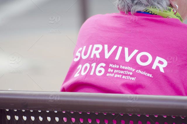 Picture from behind a woman and her shirt says survivor